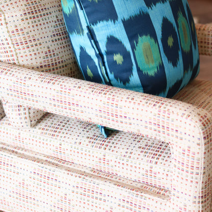 Blue and green patterned pillow on a textured chair